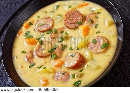 Kartoffelsuppe, German Potato Soup With Sausages In Black Bowl On  Concrete Table, Close-up