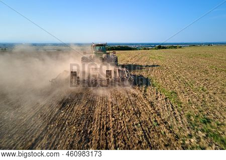 Aerial View Of Tractor Plowing Agriculural Farm Field Preparing Soil For Seeding In Summer.