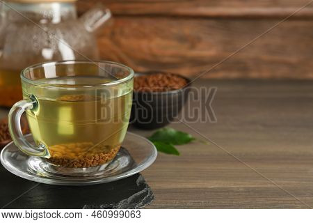 Freshly Made Buckwheat Tea In Glass Cup On Wooden Table. Space For Text