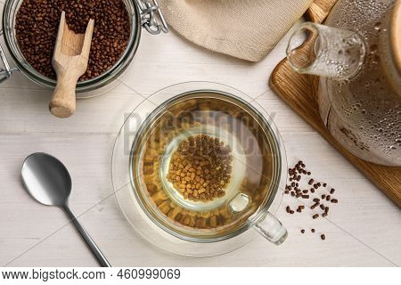 Cup With Buckwheat Tea, Hot Teapot And Granules On White Wooden Table, Flat Lay