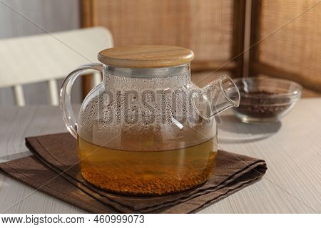 Glass Teapot With Aromatic Buckwheat Tea And Granules On Wooden Table