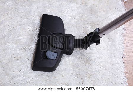 Vacuuming carpet in house