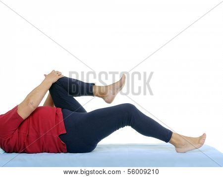Older patient performing funtional test of hip joint contraction lying on bed