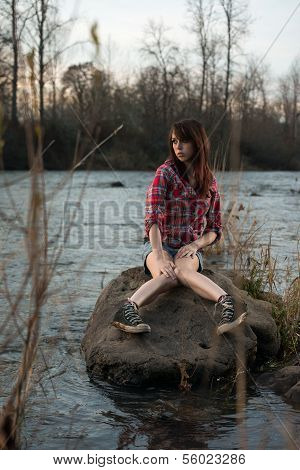 Girl Sitting On A River Rock