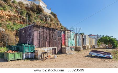 Old Fishing Huts On The Beach In The Village Of Ferragudo.