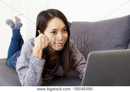 Asian woman using laptop on couch