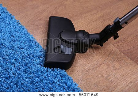 Vacuuming carpet in house