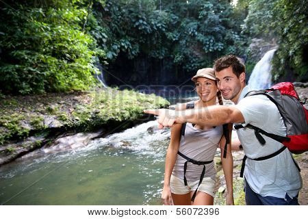 Trekkers reaching waterfall in natural landscape
