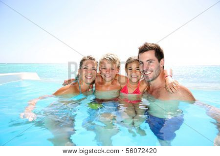 Happy family enjoying bath time in infinity pool