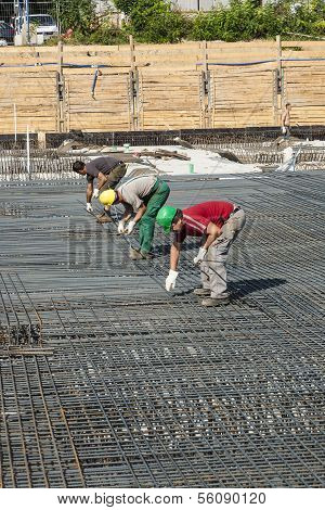 Workers Do The Steel Bars Construction At The Building Site