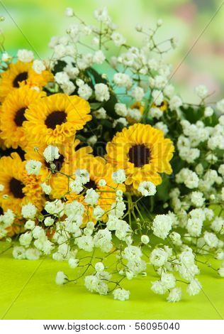 Beautiful flowers on table on bright background