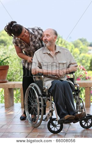 elderly man out for walk in wheelchair with grandchild