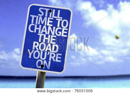 Still Time To Change the Road You're On sign with a beach on background