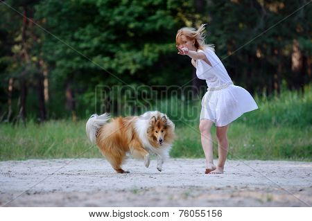 Beautiful young girl in a white dress and her collie dog