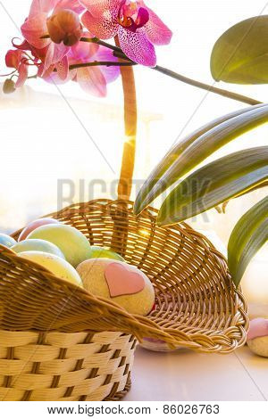 Easter eggs in a basket, stone heart, flowering Orchid
