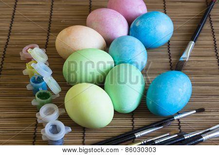 Easter eggs are dried after painting on the table, paints, brushes