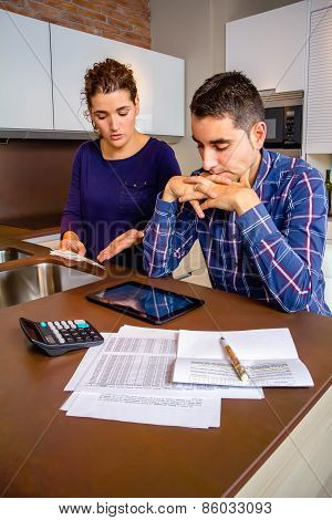 Unemployed young couple with debts reviewing their bills