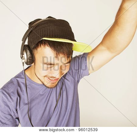 young asian man in hat and headphones listening music on white background
