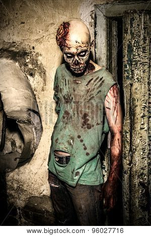 Horrible scary zombie man on the ruins of an old house. Horror. Halloween. 