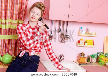 Pretty pin-up girl teenager smarten up on a pink kitchen. Beauty, youth fashion. Pin-up style.