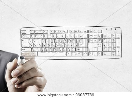 Close up of hand darwing computer keyboard with marker 