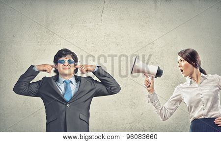 Young furious woman screaming agressively in megaphone