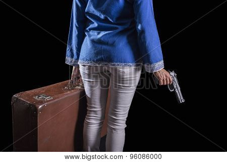 Women with Islamic headscarf subject suitcase and gun