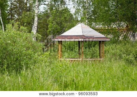 Gazebo In Thickets Of Grass And Bushes