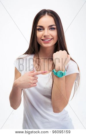 Happy young girl pointing finger at her watch isolated on a white background. Looking at camera