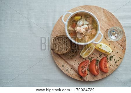 Russian traditional fish soup - ukha, served with bread lemon tomato and vodka