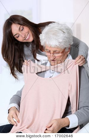 젊은 여성이 할머니에 게 새 옷을 보여주는