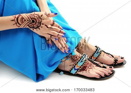 Female legs and hands with henna tattoo on white background