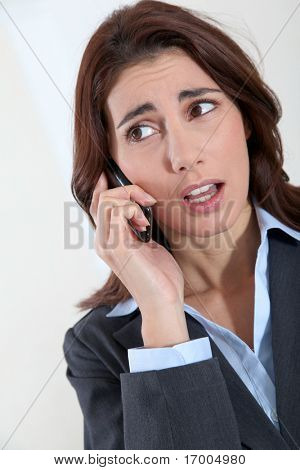 Podnikatelka na telefonu s zaujati pohledem