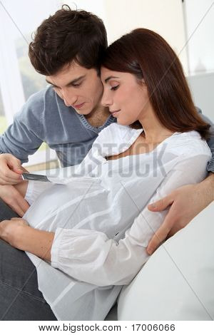 Pareja joven mirando sonograma de su futuro bebé