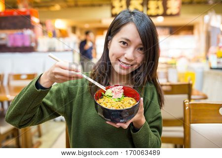 Woman having urchin rice bowl in Japanese restaurant 