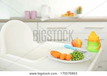 Highchair with healthy baby food at home. Child feeding concept