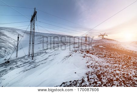 Support of the high-voltage power line. Winter mountain landscape.