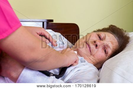 Picture of a sick elderly woman at home with her carer