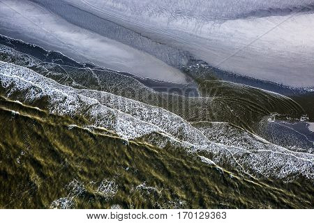 Aerial view of the shore with shapes, lines and patterns formed by the waves on the sand, Ameland islad, Friesland, The Netherlands