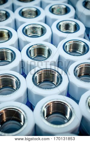 PPR Plumbing connection fittings for plastic pipes. Orderly arranged in neat rows. Abstract industrial background.