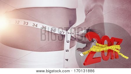 Mid section of woman measuring her waist against 3D 2017