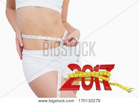 Mid section of woman measuring her waist against 3D 2017