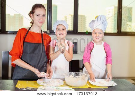Two Lovely Children Together With Mother Preparing A Cake