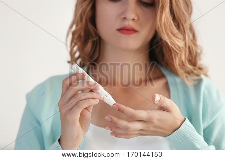 Woman using lancelet on finger