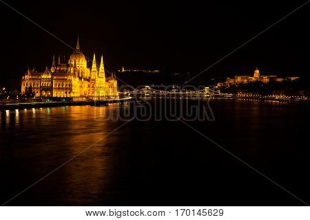 Building Of Hungarian Parliament Located At The Bank Of The Dunabe River With Famous Chain Bridge Co