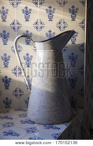 bathroom interior with enamel ewer with old style tiles in the background