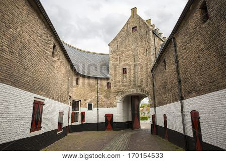 Old city gateway with small cobble stone alley and brick buildingZierikzee the Netherlands