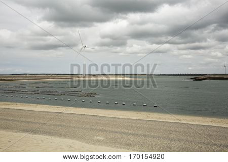 Seaside view with power windmills, a dike and dramatic sky, Haringvliet, The Netherlands