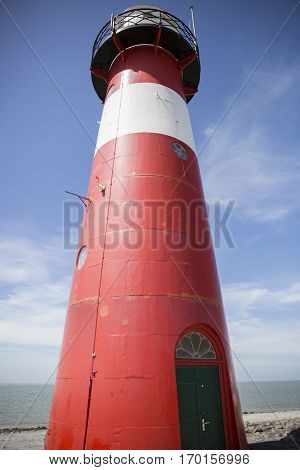 Red and white lighthouse on a blue sky background Westkapelle The Netherlands