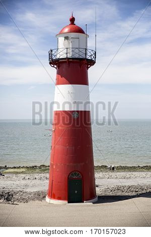 Red and white lighthouse on a blue sky background Westkapelle The Netherlands